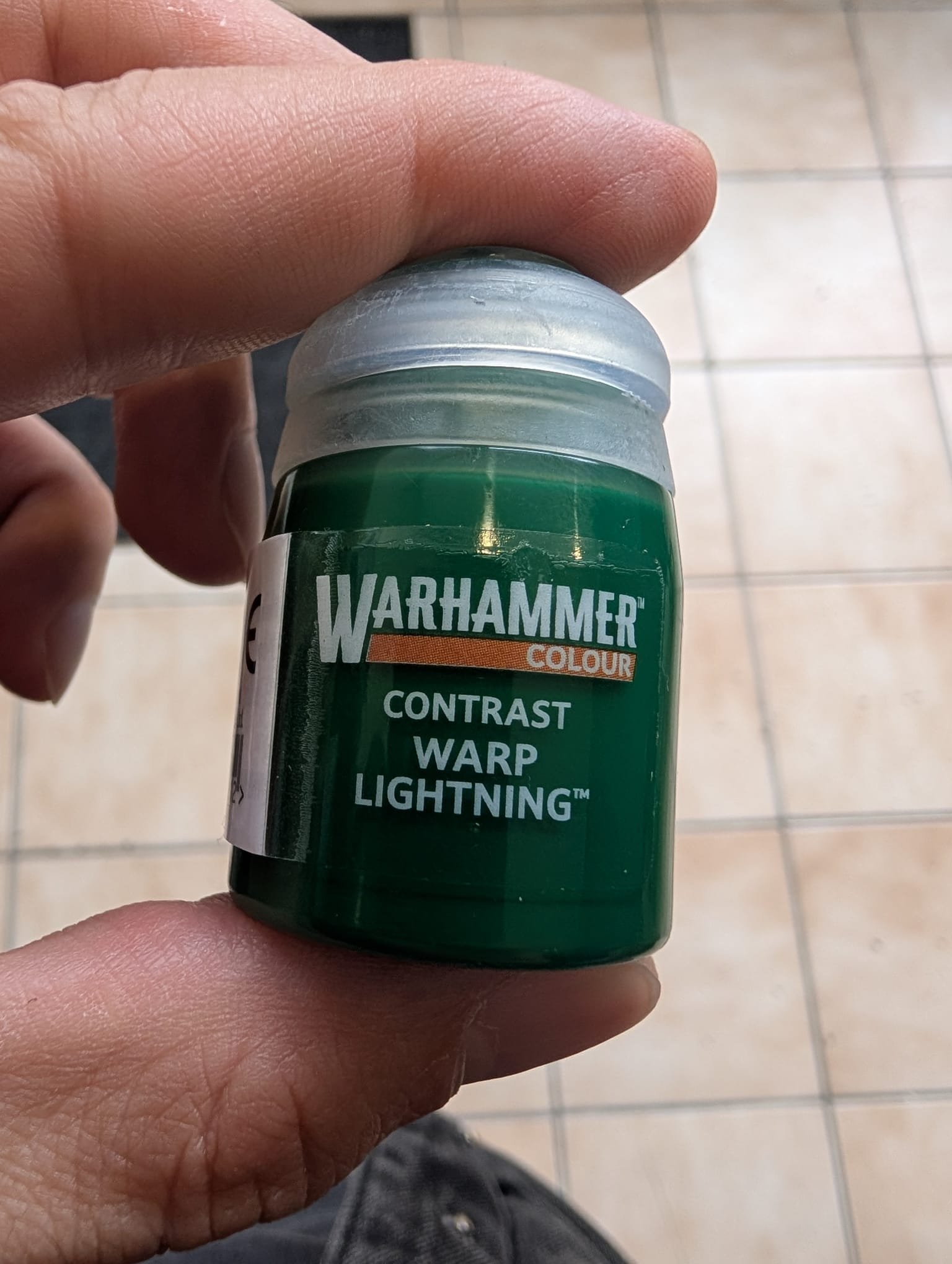 La peinture Citadel Contrast : Warp Lightning est une formule acrylique translucide de chez Games Workshop qui permet de poser une couche de base, des ombrages et des éclaircissements en une seule application. Elle offre une teinte verte électrique très vive et saturée.